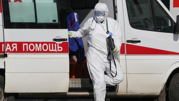 Muž v ochranném obleku proti koronaviru v Moskvě