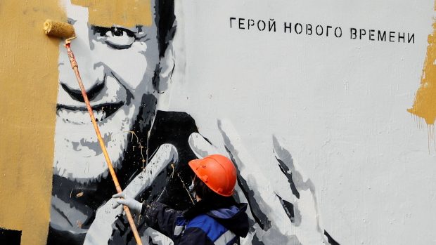 Dělník maluje na graffiti zobrazující uvězněného ruského opozičního politika Alexeje Navalného v Petrohradě 28. dubna 2021. Na graffiti je napsáno: &quot;Hrdina nové doby&quot;