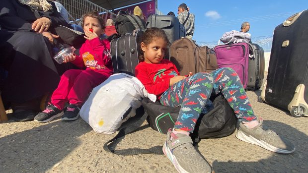 Palestinské děti s dvojím občanstvím čekají před hraničním přechodem Rafáh s Egyptem v naději, že dostanou povolení opustit Gazu
