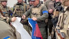 Vjačeslav Zadorenku rozřezává ruskou vlajku ve městě Kozača Lopan v Charkovské oblasti