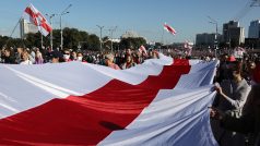 Protestující v Minsku pochodují s historickou vlajkou Běloruska.