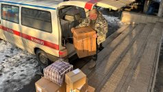 Čeští humanitární dobrovolníci Alois Zwesper a Petr Drápal otevírají dvě dodávky napěchované až po střechu pomocí