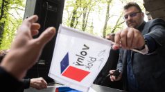 Nezařazený poslanec Lubomír Volný podpisuje během protestní akce na Střeleckém ostrově vlajky.