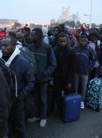 Migranti se zavazadly čekají na odvoz z uprchlického tábora u Calais, takzvané Džungle