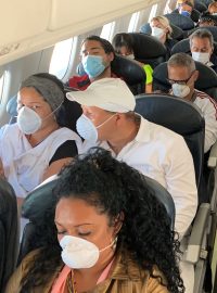 Cestující v letadle vybaveni rouškami a respirátory
