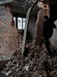 Obyvatelé si prohlížejí škody na několikapatrové obytné budově poškozené střepinami ze sestřeleného bezpilotního letounu kamikadze ruské armády v Kyjevě (foto z 22. 12. 2023)