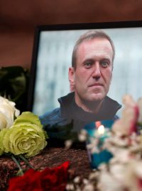 Květiny a svíčka jsou položeny vedle portrétu ruského opozičního vůdce Alexeje Navalného