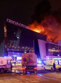 Vozidla ruských záchranných složek parkují u hořící koncertní haly Crocus City Hall po nahlášené střelbě, u Moskvy, Rusko, 22. března 2024