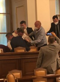 Ochranka vyvádí poslance Lubomíra Volného ze sněmovny