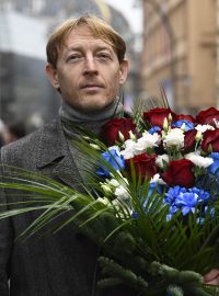 Kandidát na prezidenta Karel Janeček nese květinu v národních barvách 17. listopadu na Národní třídu