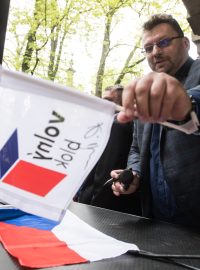 Nezařazený poslanec Lubomír Volný podpisuje během protestní akce na Střeleckém ostrově vlajky.