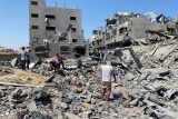 Palestinci si prohlížejí škody na budovách po izraelských náletech v Gaze