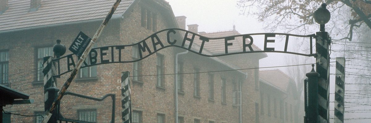 Vstup do Osvětimi: brána s nápisem Arbeit Macht Frei