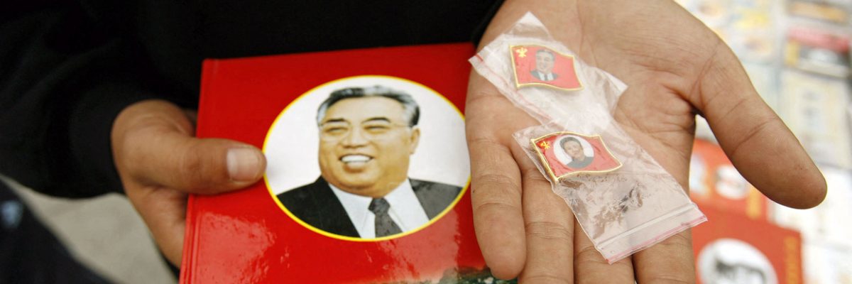Prodavač v čínském Tan-tungu na hranici s KLDR nabízí zákazníkům odznaky s portréty Kim Ir-sena a Kim Čong-ila (archivní snímek z října 2006).
