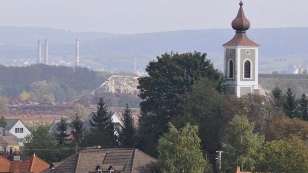 Důvod tak tragických následků protržení hráze hliníkárny je neuvěřitelně prostý - odkalovací nádrž hliníkárny (šedá plocha vlevo od kostela) totiž leží poněkud nepochopitelně přímo nad obcí Kolontár.