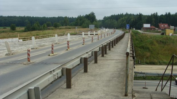 Chodníček na kraji mostu přes dálnici D3 na jednom konci končí v poli a na druhém prochází okružní křižovatku