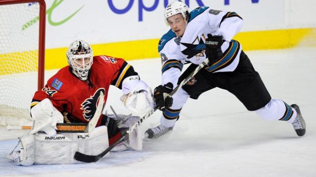 Calgary Flames&#039; goalie Miikka Kiprusoff (L) makes a save on San Jose Sharks&#039; Justin Braun during the overtime period of their NHL