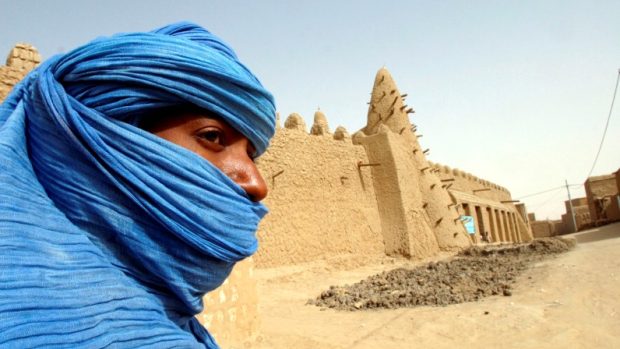 Příslušník kmene Tuaregů u mešity ze 13. století v Timbuktu