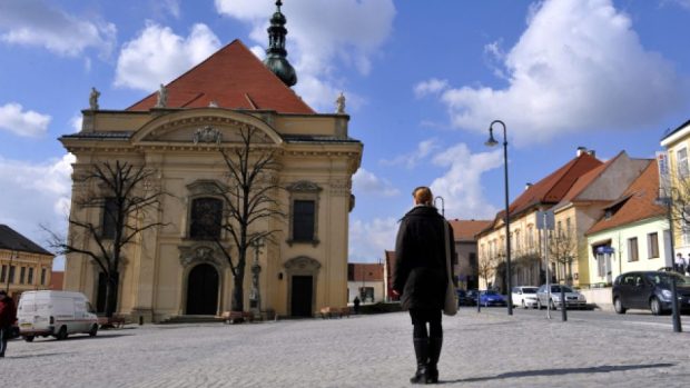 Žena stojící na Masarykově náměstí v Uherském Brodě poslouchá zvony, které se v poledne rozezněly na památku osmi obětí útoku v místní restauraci Družba