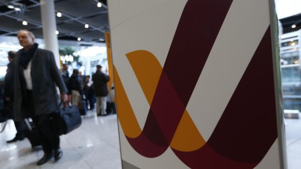 Cestující míjí na letišti v Düsseldorfu logo společnosti Germanwings. Její stroj se zřítil při cestě z Barcelony