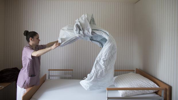 Ošetřovatelka upravuje postel (ilustrační foto)
