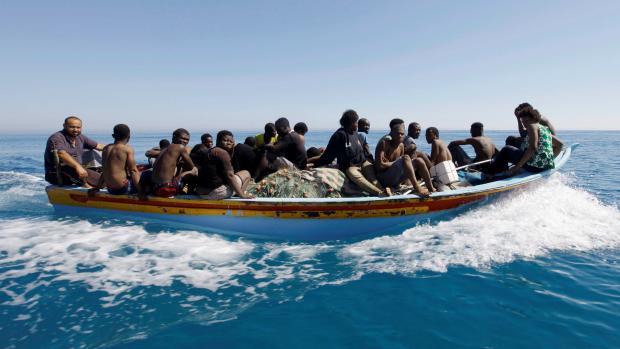 Migranti na lodi poté, co je zachránila pobřežní hlídka u libyjských břehů.