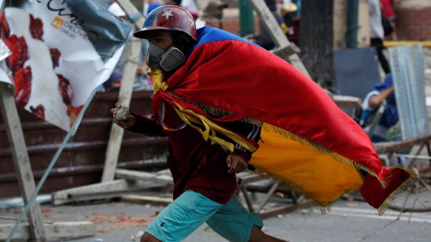 Demonstrant utíká před policií na protestech ve Venezuele proti prezidentovi.