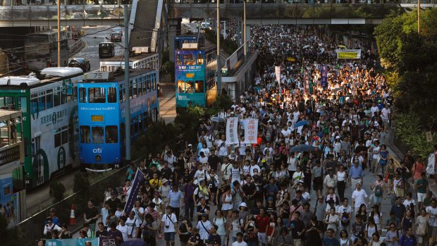 Desetitisíce lidí protestují v Hongkongu proti uvěznění tří vůdců protičínských protestů.