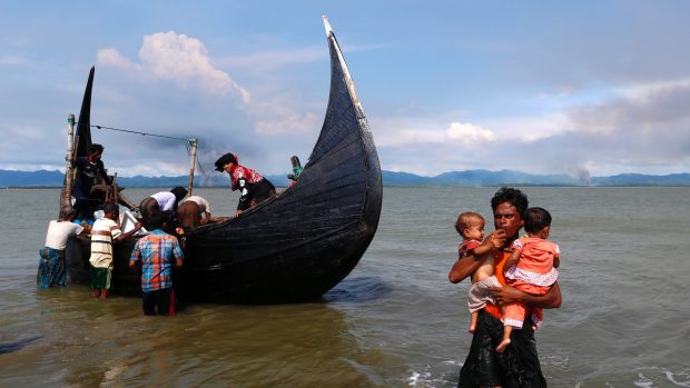 Rohingská rodina uprchla z Barmy do Bangladéše, v pozadí kouř z rohingských vesnic v Barmě