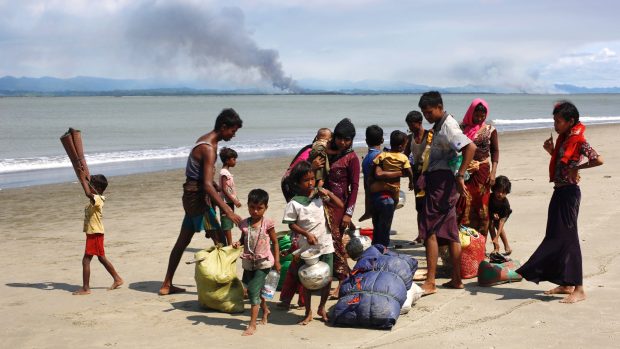 Rohingská rodina uprchla z Barmy do Bangladéše, v pozadí kouř z rohingských vesnic v Barmě