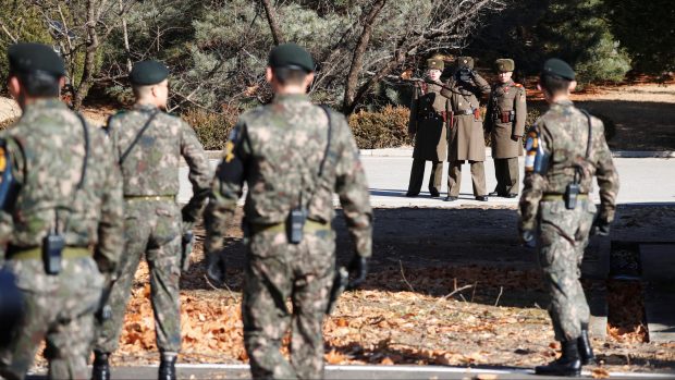 Severokorejští (v pozadí) a jihokorejští vojáci na hlídce nedaleko místa, kde před dvěma týdny překročil zběh hranici s Jižní Koreou