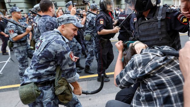 Příslušník národní gardy útočí na protestujícího muže při demonstraci za penzijní reformu v Moskvě