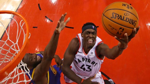 Útočník Toronta Pascal Siakam (vpravo) se prosazuje přes Draymonda Greena z Golden State