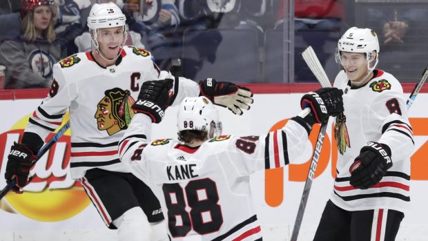 Dominik Kubalík (vpravo) slaví se spoluhráči (Patrick Kane uprostřed, Jonathan Toews vlevo) gól do sítě Winnipegu.