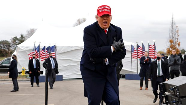 Donald Trump reaguje na chladné počasí na předvolebním sjezdu v Michiganu.