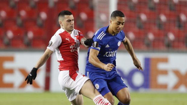 Youri Tielemans si kryje míč před Nicolaem Stanciuem