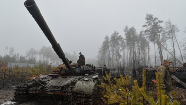 Ukrajinci prohlížení zničený ruský tank u obce Dmytrivka na severu země