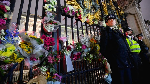 Lidé přinášejí květiny, které kladou na brány Buckinghamského paláce, který je je oficiálním sídlem britského panovníka