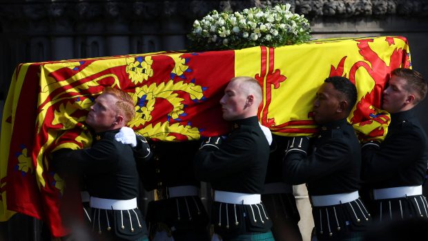 Smuteční průvod s rakví zesnulé britské královny Alžběty II. se v pondělí vydal z paláce Holyroodhouse do katedrály svatého Jiljí v Edinburghu. Rakev byla překrytá žlutočervenou královskou standartou Skotska. Vůz po obou stranách doprovázeli příslušníci Královské společnosti lukostřelců