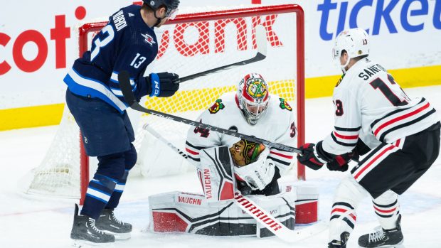 Brankář Petr Mrázek v dresu Chicago Blackhawks brání proti Gabrieli Vilardimu