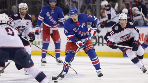 Artěmij Panarin s pukem proti hráčům Columbus Blue Jackets