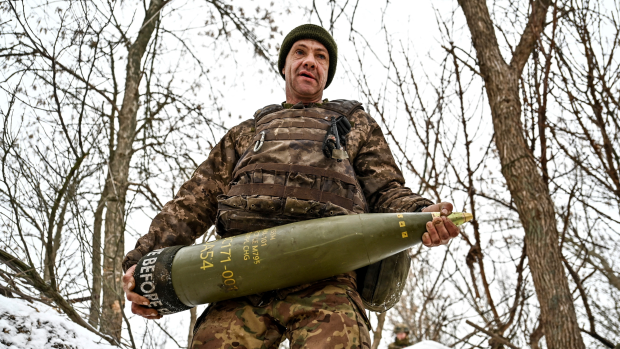 Ukrajinský voják nese 155mm dělostřelecký granát (archivní foto)
