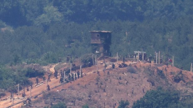 Severokorejci na hranici pracují na vojenském plotu u strážního stanoviště