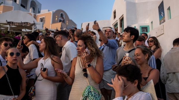 Turisté pozorují proslulý západ slunce na Santorini