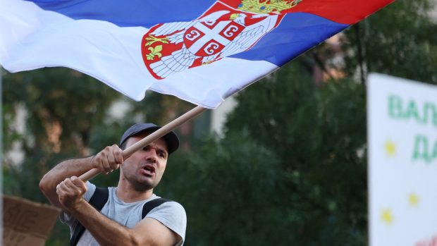 Muž mává srbskou vlajkou při protestu proti projektu těžby lithia společnosti Rio Tinto v srbském Bělehradě 10. srpna 2024