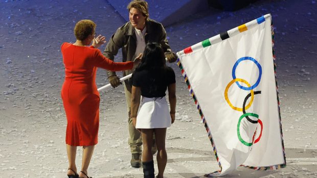 Herec Tom Cruise předává olympijskou vlajku starostce Los Angeles za doprovodu gymnastky Simone Bilesové