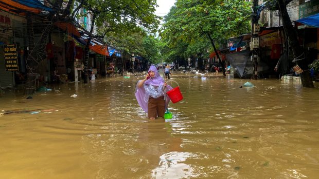 Žena se brodí zaplavenou ulicí ve městě Thai Nguyen ve Vietnamu. Kvůli supertajfunu Yagi zemřelo ve Vietnamu přes 140 lidí