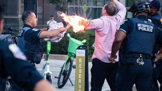 Policie pomáhá muži, který se pokusil zapálit při demonstraci u příležitosti výročí války mezi Hamásem a Izraelem před Bílým domem ve Washingtonu