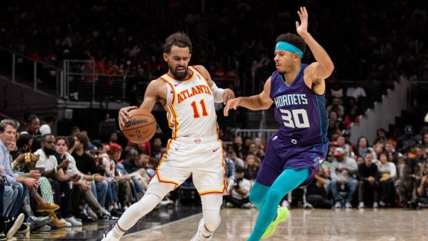 Trae Young z Atlanty Hawks (vlevo) v zápase NBA proti Charlotte Hornets