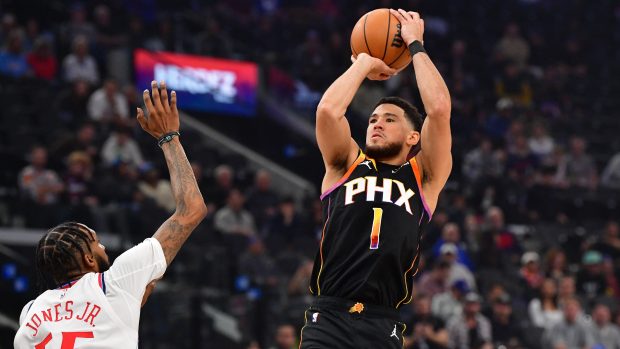 Devin Booker střílí přes bránícího Derricka Jonese Jr.